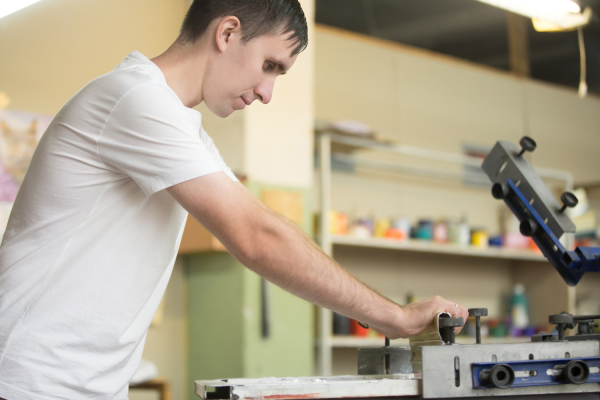 Man operating screen printing machine